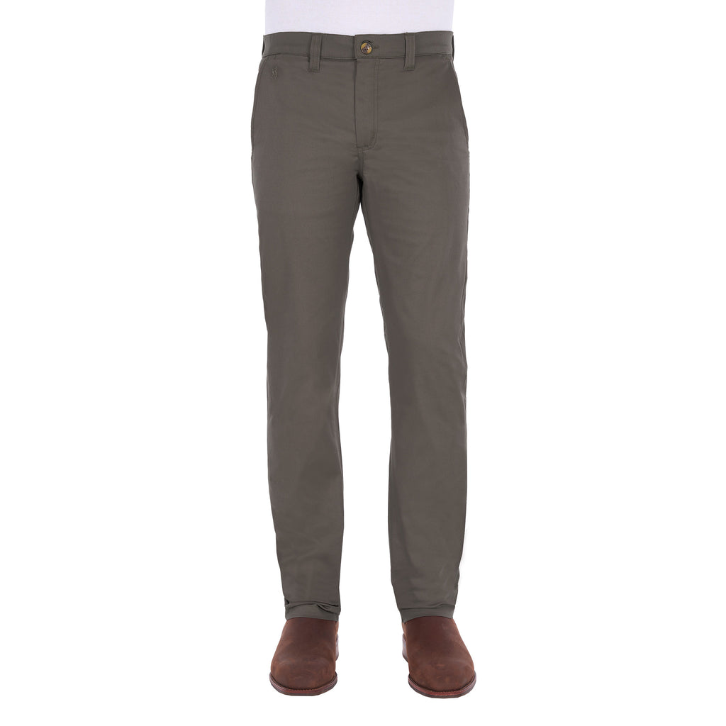 A man modelling a pair of greystone Thomas Cook Men's Tailored Mossman Trousers (TCP1209091) paired with a white tee and brown boots on a white background.