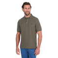 A man modelling a military green Thomas Cook Men's Tailored Short Sleeve Polo (TCP1506009) paired with blue denim jeans on a white background.