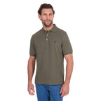 A man modelling a military green Thomas Cook Men's Tailored Short Sleeve Polo (TCP1506009) paired with blue denim jeans on a white background.
