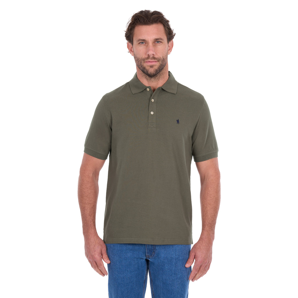 A man modelling a military green Thomas Cook Men's Tailored Short Sleeve Polo (TCP1506009) paired with blue denim jeans on a white background.