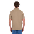 A man shown from behind, modelling a sand coloured Thomas Cook Men's Tailored Short Sleeve Polo (TCP1506009) paired with blue denim jeans on a white background.