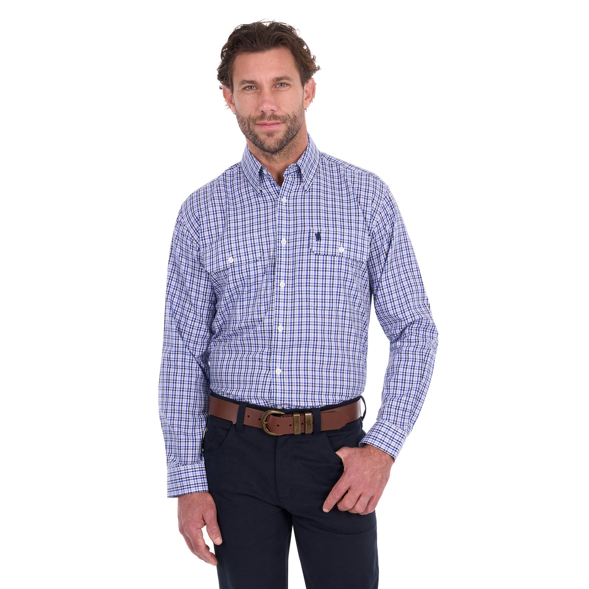 A man modelling a navy, blue and white Thomas Cook Men's Wentworth Long Sleeve Shirt (TCP1115158) paired with navy blue pants and a brown leather belt on a white background.