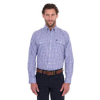 A man modelling a navy, blue and white Thomas Cook Men's Wentworth Long Sleeve Shirt (TCP1115158) paired with navy blue pants and a brown leather belt on a white background.