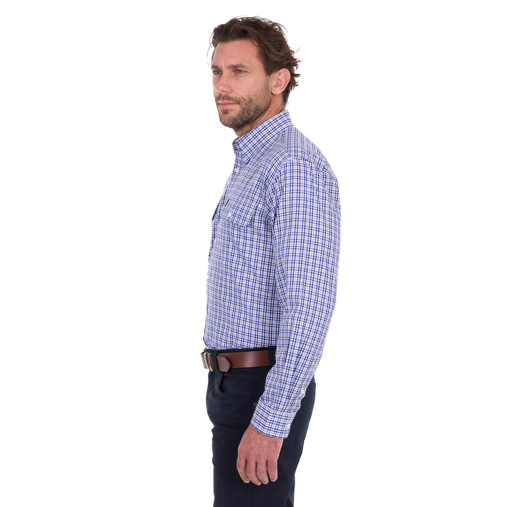 A man in profile modelling a navy, blue and white Thomas Cook Men's Wentworth Long Sleeve Shirt (TCP1115158) paired with navy blue pants and a brown leather belt on a white background.