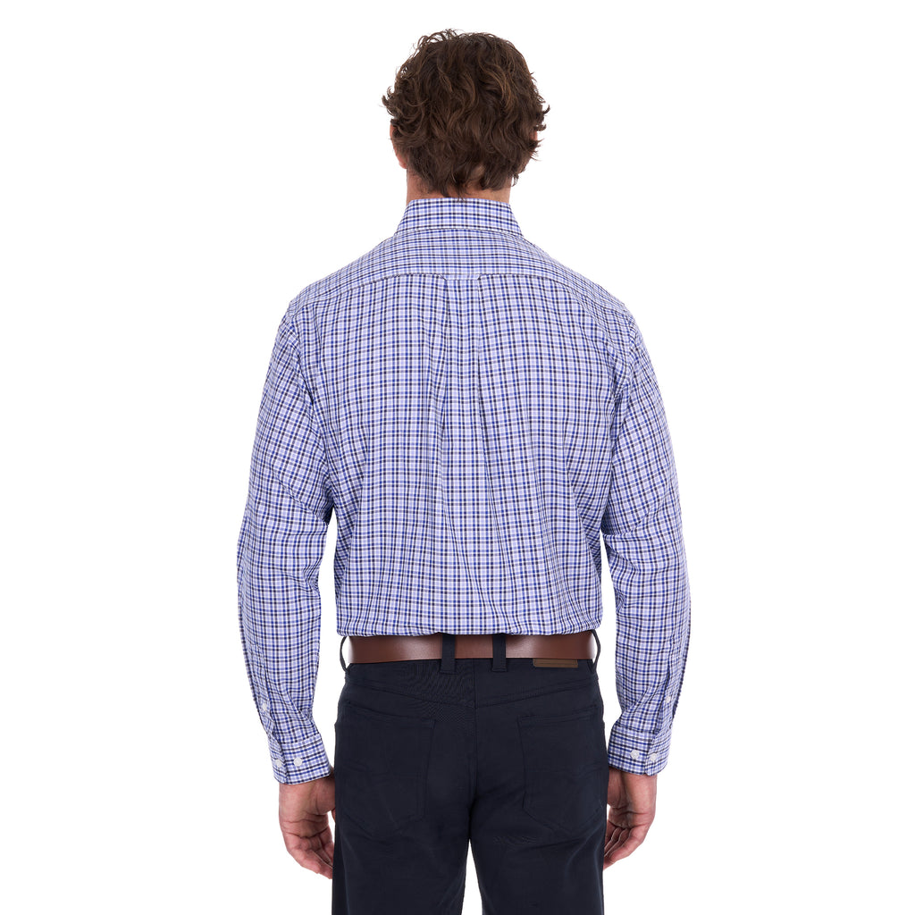 A man viewed from behind modelling a navy, blue and white Thomas Cook Men's Wentworth Long Sleeve Shirt (TCP1115158) paired with navy blue pants and a brown leather belt on a white background.