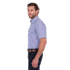 A man in profile modelling a navy blue and white Thomas Cook Men's Wentworth Short Sleeve Check Shirt (TCP1110158) with navy blue pants and a brown belt.