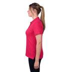 A woman modelling a bright rose coloured Thomas Cook Women's Classic Stretch Short Sleeve Polo Shirt (TCP2512059) with a small navy embroidered logo on the left chest, set against a plain white background.