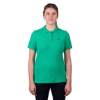 A woman wearing a peppermint green Thomas Cook Women's Classic Stretch Short Sleeve Polo with a Thomas Cook embroidered logo on a white background.