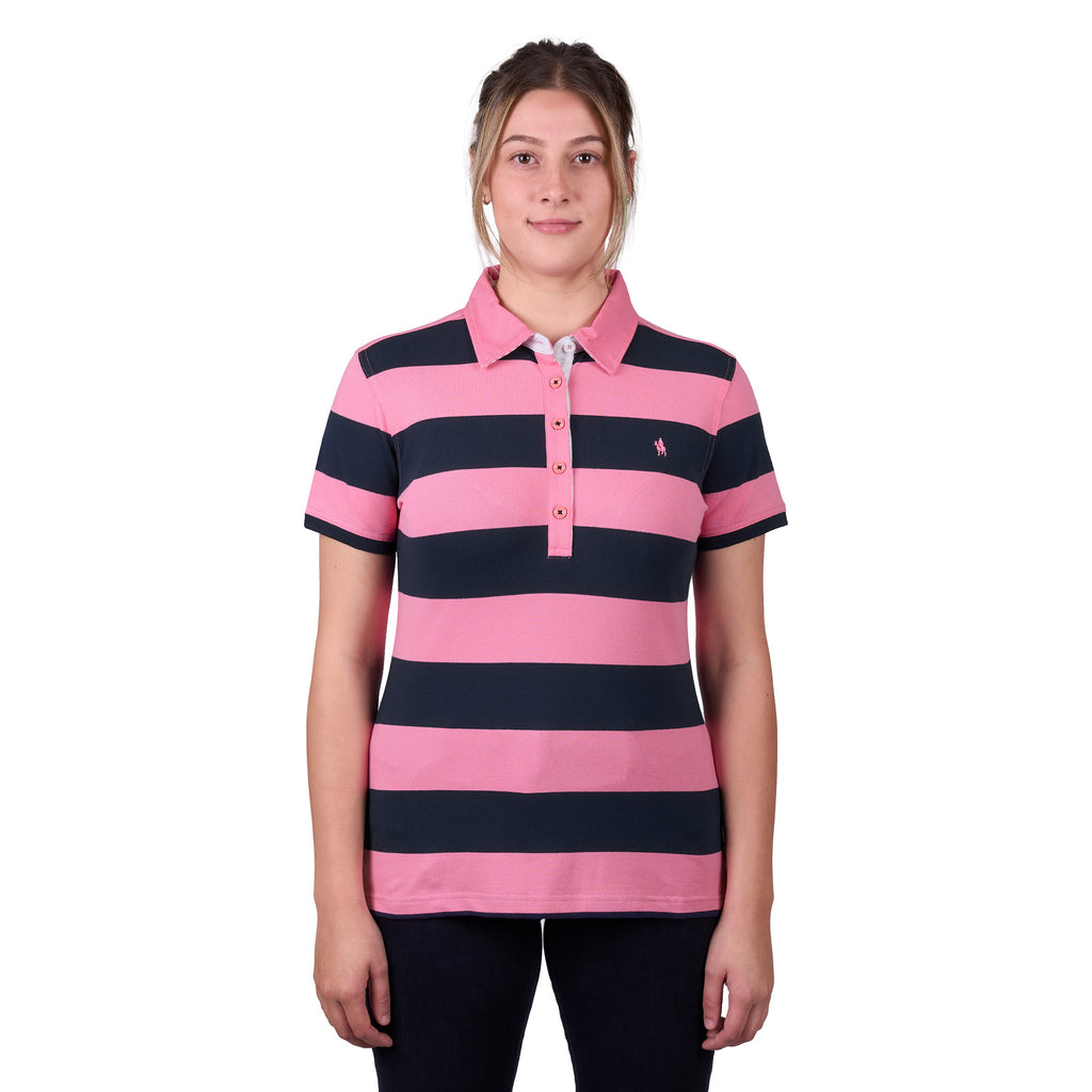 A woman modelling a dark navy and soft pink Thomas Cook Women's Rachel Stripe Polo (TCP2501053) paired with dark pants on a white studio background.