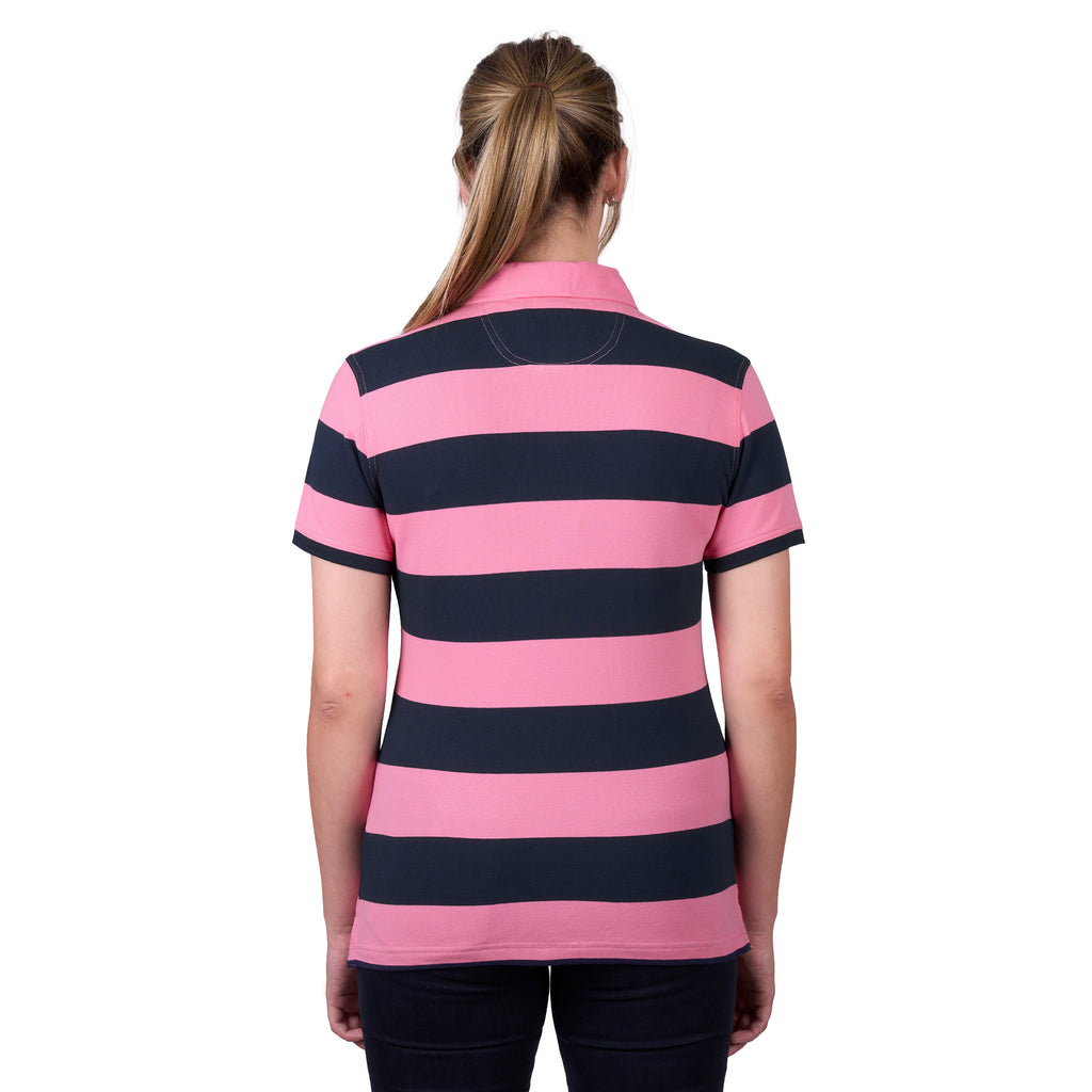 A woman viewed from behind, modelling a dark navy and soft pink Thomas Cook Women's Rachel Stripe Polo (TCP2501053) paired with dark pants on a white studio background.