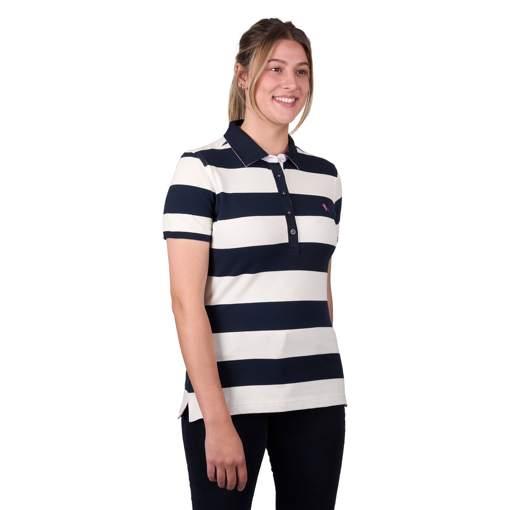 A woman modelling a dark navy and white Thomas Cook Women's Rachel Stripe Polo (TCP2501053) paired with dark pants on a white studio background.