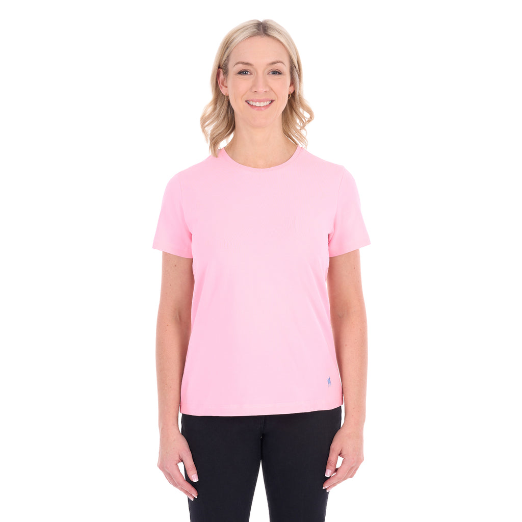 A woman modelling a rose pink Thomas Cook Women's Round Neck Short Sleeve Tee (TCP2515104) paired with blue denim jeans on a white background.