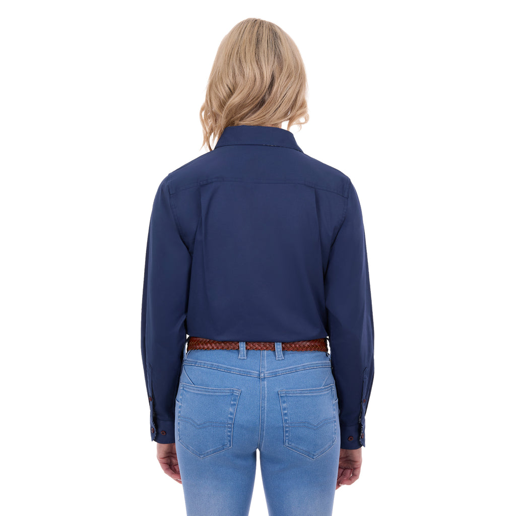 A woman viewed from behind, modelling a navy blue Thomas Cook Women's Stretch Drill Half Button Long Sleeve Work Shirt (TCP2100106), paired with blue jeans and a brown woven belt, against a plain white background.