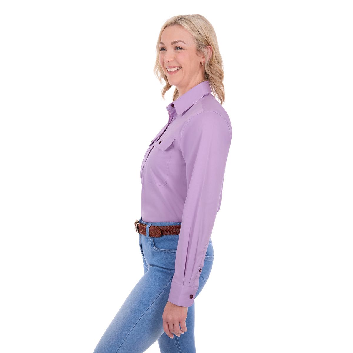 A woman in side profile wearing a lilac Thomas Cook Women's Stretch Drill Half Button Long Sleeve Work Shirt (TCP2100106) tucked into light blue jeans with a brown braided belt, against a plain white background.