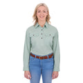 A woman modelling a mint green Thomas Cook Women's Stretch Drill Half Button Long Sleeve Work Shirt (TCP2100106) with two chest pockets, paired with blue jeans and a brown woven belt, against a plain white background.