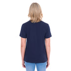 A woman viewed from behind with blonde hair wearing a navy blue Thomas Cook Women's V Neck Short Sleeve Tee (TCP2550105) and denim jeans, standing against a plain white background.