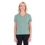 A woman with blonde hair wearing a sage green Thomas Cook Women's V Neck Short Sleeve Tee (TCP2550105) and black pants, standing against a plain white background.