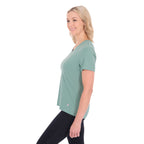 A woman in profile with blonde hair wearing a sage green Thomas Cook Women's V Neck Short Sleeve Tee (TCP2550105) and black pants, standing against a plain white background.
