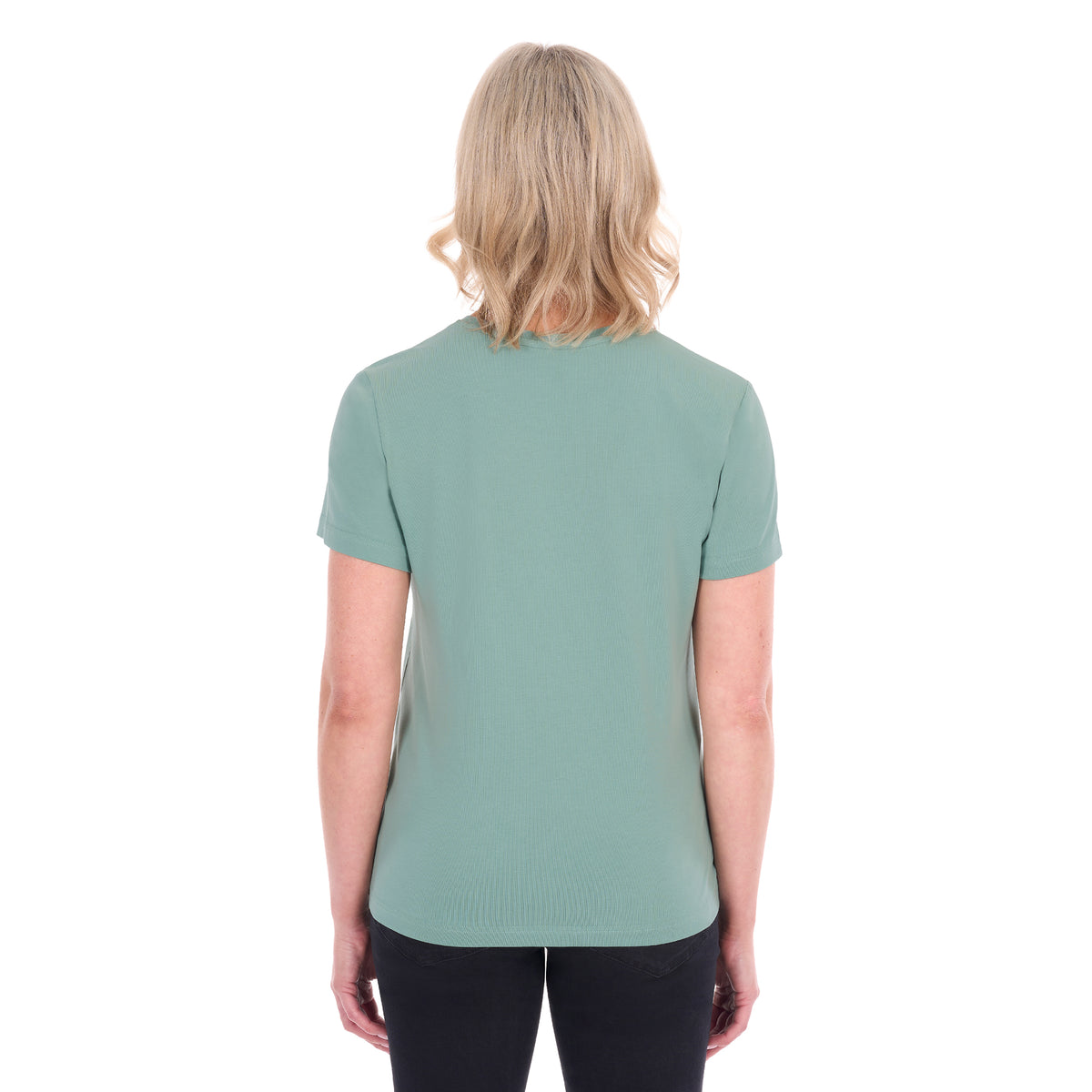 A woman viewed from behind with blonde hair wearing a sage green Thomas Cook Women's V Neck Short Sleeve Tee (TCP2550105) and black pants, standing against a plain white background.