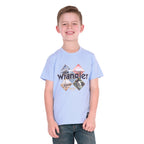 A smiling young boy wearing a light blue Wrangler Boys Mark Short Sleeve Tee (X6S3557688) with a graphic print on the front, paired with dark blue jeans, photographed against a solid white background.