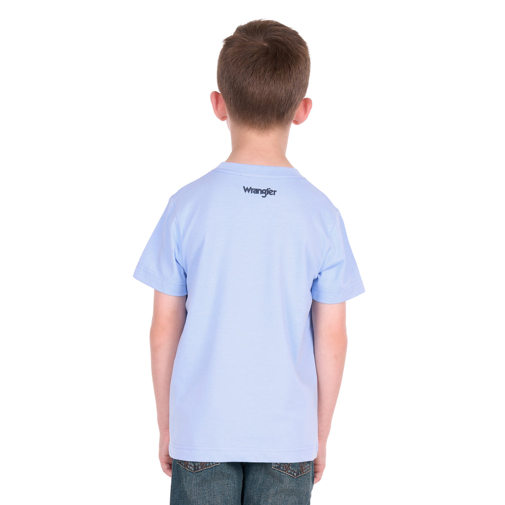 A young boy photographed from behind wearing a light blue Wrangler Boys Mark Short Sleeve Tee (X6S3557688) with a Wrangler logo back neck label, paired with dark blue jeans, photographed against a solid white background.