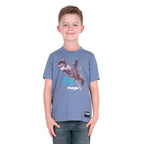 A young boy wearing a storm blue Wrangler Boys Michael Short Sleeve Tee (X6S3557684) with a cowboy graphic print, paired with blue jeans, standing against a solid white background.