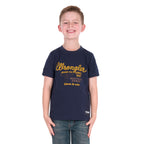 A young boy with a broad smile wearing a Wrangler Boys Robert Short Sleeved Tee (X6S3557687) in Navy with a pair of denim jeans.