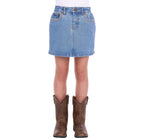 A girl wearing a faded blue Wrangler Girls Grace Skirt (X6S5202720) with decorative stitching and brown cowboy boots, against a plain white background.