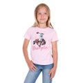 A young girl with blonde hair wearing a pastel pink Wrangler Girls Jenna T-Shirt (X6S5598639) with a cowboy graphic and blue jeans, standing against a plain white background.