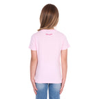 A young girl with blonde hair photographed from behind wearing a pastel pink Wrangler Girls Jenna T-Shirt (X6S5598639) with a back neck Wrangler logo and blue jeans, standing against a plain white background.