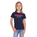 A young girl with blonde hair wearing a navy blue Wrangler Girls Maya T-Shirt (X6S5598649) and blue jeans, standing against a plain white background.