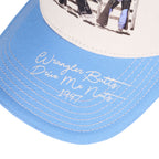 A light blue and cream Wrangler Josie High Profile Trucker Cap (X6S2943CAP) featuring a western-themed graphic print on the front panel and cream embroidered text on the brim.