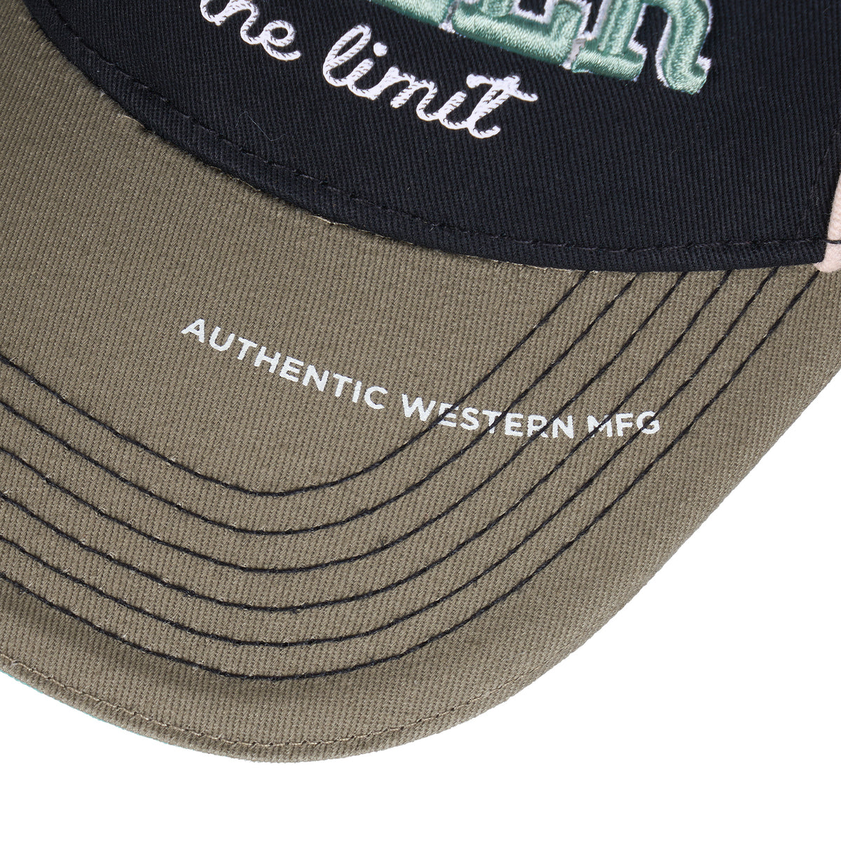 Close-up of a baseball cap showing the dark navy front panel with embroidered script and teal lettering, plus the sage green curved brim with black stitching and white print reading 'AUTHENTIC WESTERN MFG'.