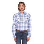A man wearing a light blue, royal blue and white Wrangler Men's Eric long-sleeve western-style plaid button-down Shirt (X6S1111667) paired with dark blue jeans, set against a plain white background.