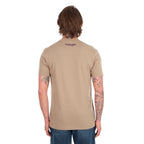 A man viewed from behind wearing a tan Wrangler Men's James Short Sleeve T-Shirt (XCP1557686) with a logo back neck print, paired with blue jeans, photographed against a solid white background.