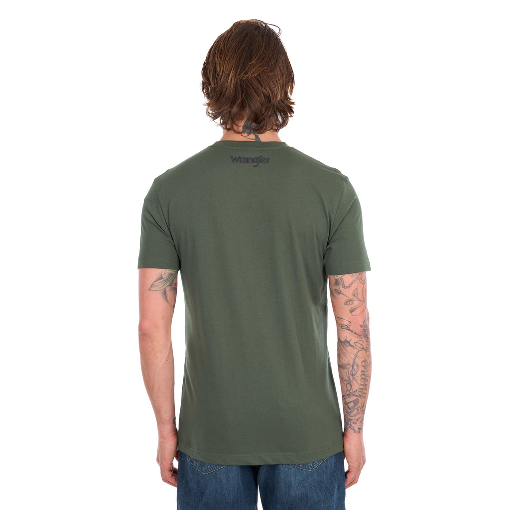 A man from behind wearing a cypress green Wrangler Men's Jay Short Sleeve T-shirt (XCP1557683) with a small Wrangler logo on the left chest, paired with blue jeans, photographed against a solid white background.
