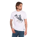 A man wearing a white Wrangler Men's Michael Short Sleeve Tee (X6S1557684) with a graphic of a cowboy riding a bucking bronco and the text 'where legendary lives' and a Wrangler logo, paired with blue jeans, against a plain white background.
