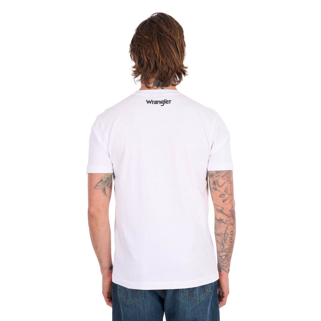 A man viewed from behind wearing a white Wrangler Men's Michael Short Sleeve Tee (X6S1557684) with a graphic of a cowboy riding a bucking bronco and the text 'where legendary lives' and a Wrangler logo, paired with blue jeans, against a plain white background.