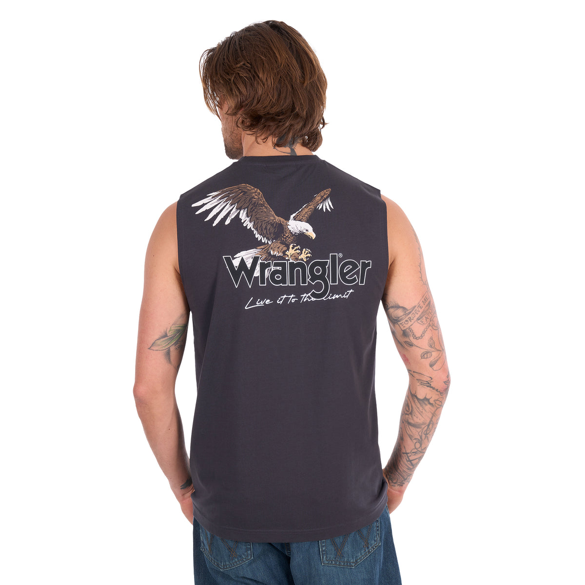 A man with his back to the camera wearing a Wrangler Men's Paul Muscle Tank with a Wrangler logo and a large print of an eagle on it (XCP1572700) in Charcoal with a pair of denim jeans.