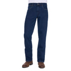 A man wearing a pair of original rinse dark blue Wrangler Men's Regular Bootcut Jeans (XLR1201032) with brown boots against a plain white background.