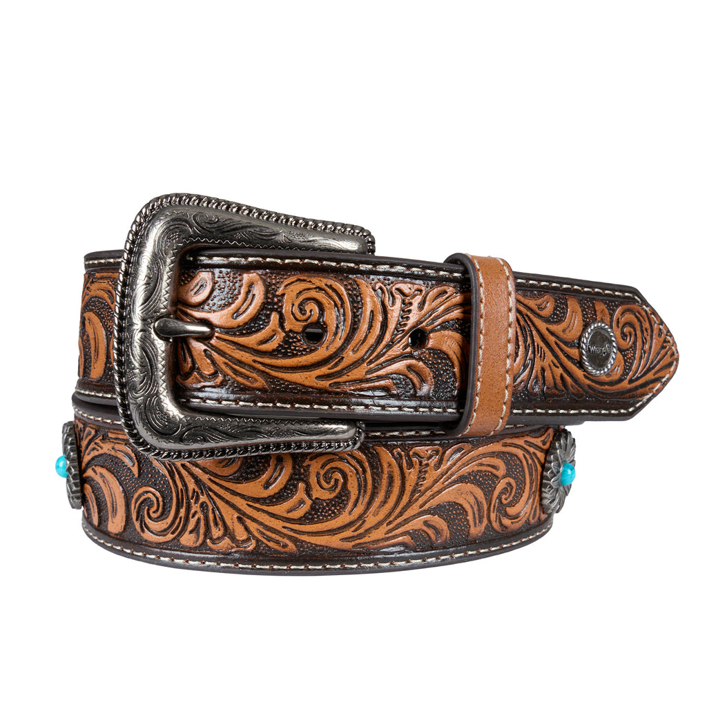 A tan tooled leather western Wrangler Siara Belt (X6S2916BLT) with an antique silver toned metal buckle, intricate brown and black floral scrollwork tooling and small turquoise accents on the sides, shown on a white background.