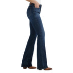A woman in profile photographed from the waist down modelling a pair of Lacey Wrangler Women's Bespoke Hi Rise Bootcut Jeans (112359277) with brown boots on a white background.