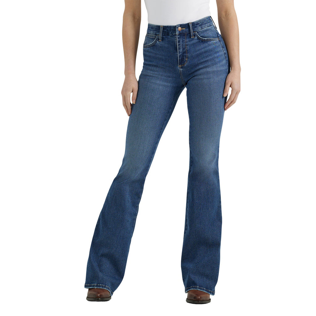 A woman shown from the waist down modelling a pair of Wrangler Women's Bespoke Hi Rise Flare Jeans (112359281) paired with a white tee and brown pointed boots on a white background.