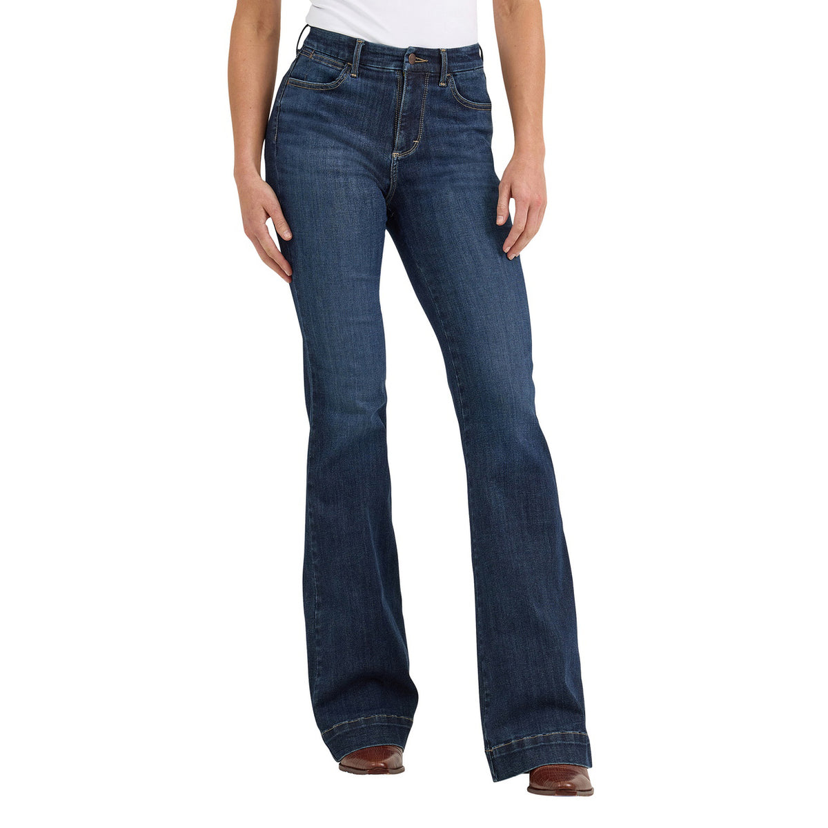 A woman modelling a pair of Alexandra blue Wrangler Women's Bespoke Hi Rise Trouser Jeans (112367600) with a slight flare, paired with a white top and brown boots, against a plain white background.
