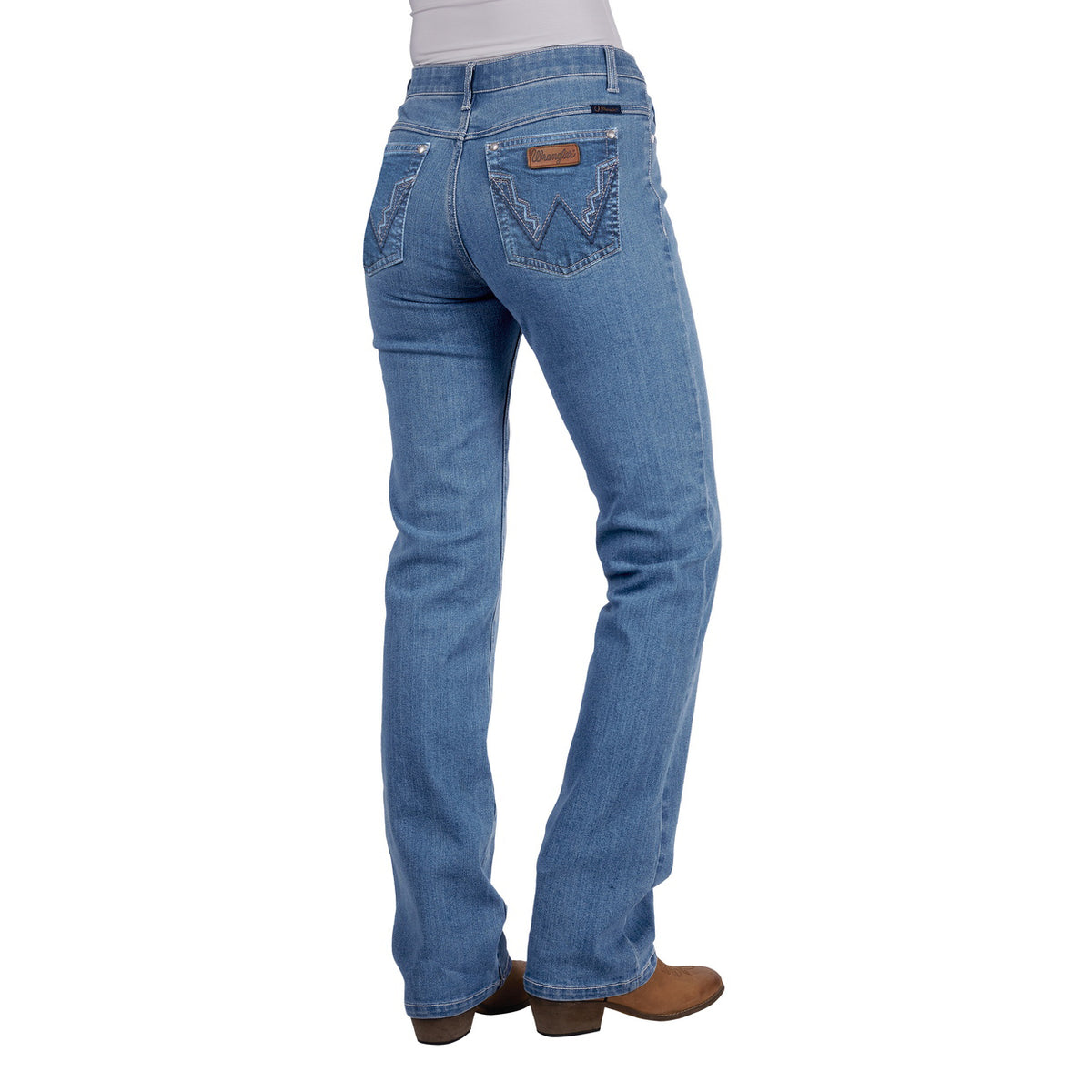 Rear view of a woman wearing faded blue Wrangler Women's Chara Willow Jeans (XCP2251216) with decorative stitching on the back pockets and brown cowboy boots, shown against a plain white background.