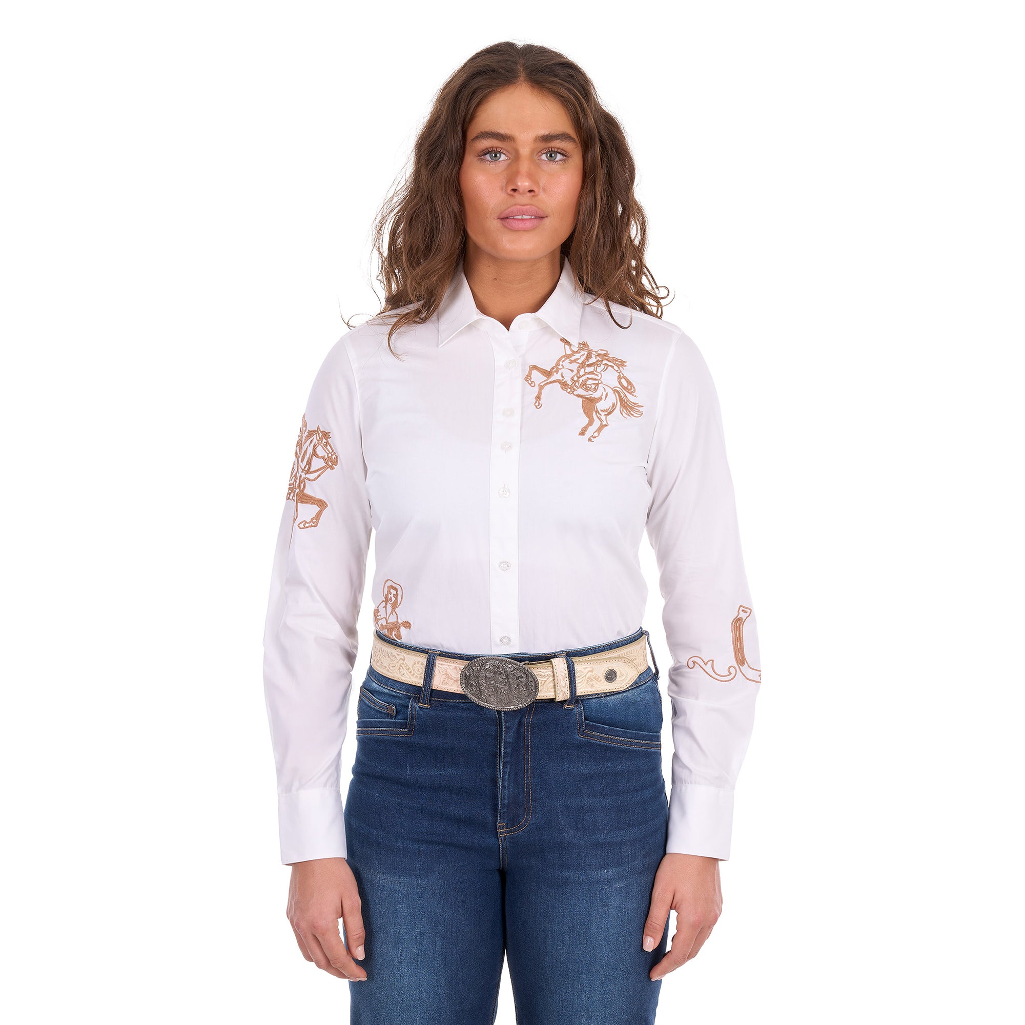 A woman modelling a white Wrangler Women's Darcy Long Sleeve Shirt (X6S2100606) with embroidered horse motifs on the chest and sleeves, paired with blue jeans and a Wrangler Zola Belt (XCP2918BLT) in Stone, against a plain white background.