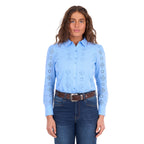 A woman modelling a cornflower blue Wrangler Women's Fleur Long Sleeve Shirt (X6S2104600) with embroidered Aztec inspired patterns, paired with dark blue jeans and a tan Wrangler Molly Belt (XCP2919BLT), against a plain white background.