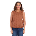 A woman modelling a copper Wrangler Women's Grace Sleeveless Blouse (X6S2502615) with eyelet embroidery and a ruffled hem, paired with blue jeans, against a plain white background.