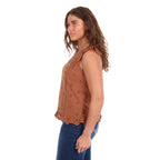 A woman viewed in profile modelling a copper Wrangler Women's Grace Sleeveless Blouse (X6S2502615) with eyelet embroidery and a ruffled hem, paired with blue jeans, against a plain white background.