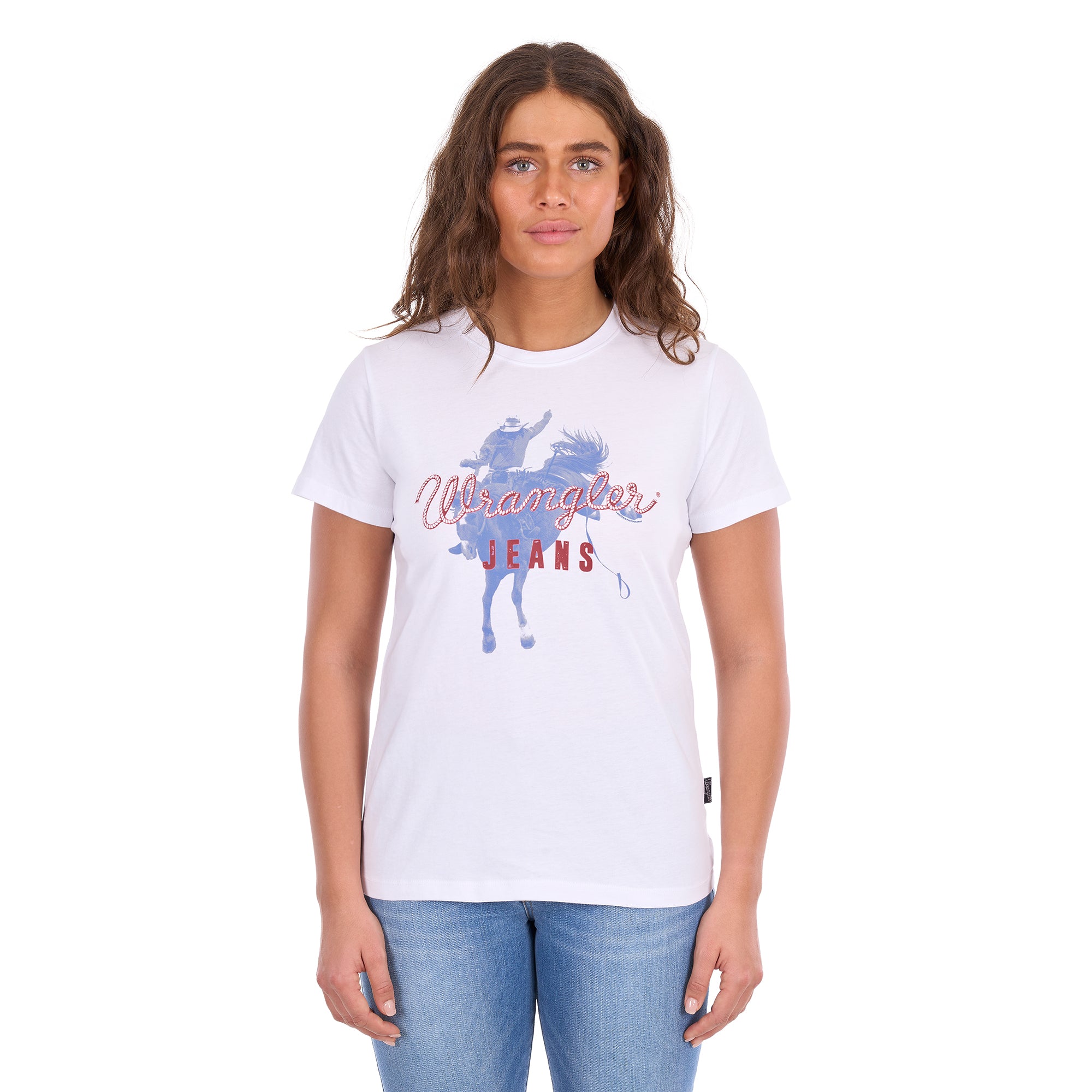 A woman modelling a white Wrangler Women's Gwen Tee (X6S2598635) t-shirt with a blue and red graphic on the front, paired with blue jeans, against a plain white background.